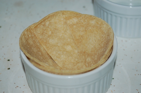 Overlap the cut edges to make a little bowl shape in the ramekin.